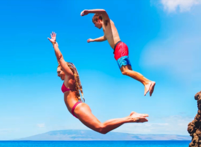 Bazaart Remove objects tool - selecting a jumping boy to erase from a Hawaii cliff-diving photo, leaving only the woman in mid-air.